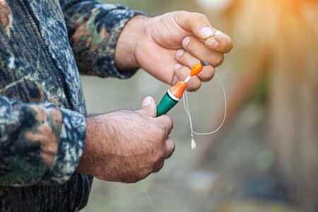 fishing hook in the hands of the fisherman in nature
