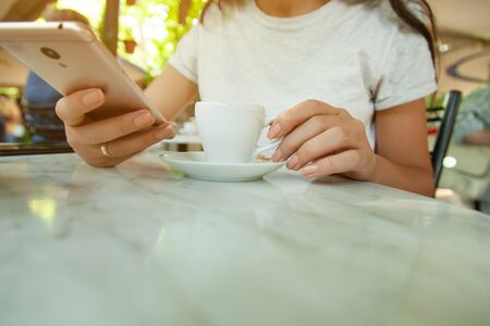 woman hand phone with coffee in cafeの写真素材