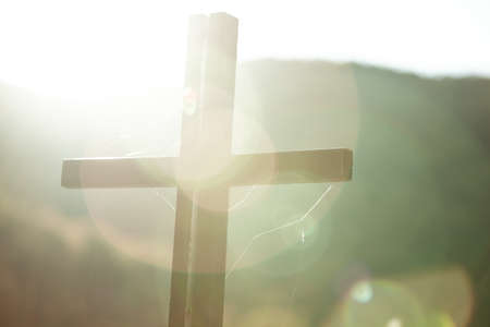 cross in nature at the sunset backgroundの写真素材