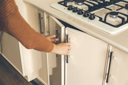 young woman hand in kitchen door backgroundの写真素材