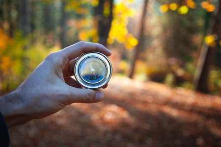 man hand compass in autumn forest backgroundの写真素材