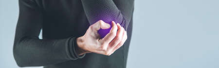 man hand in ache elbow on gray background