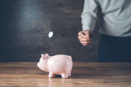 man hand coins with piggy bank on deskの写真素材