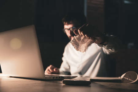 angry man hand crushed paper working in computerの写真素材