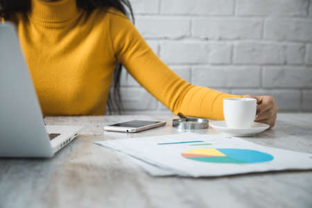 woman hand coffee in office table backgroundの写真素材