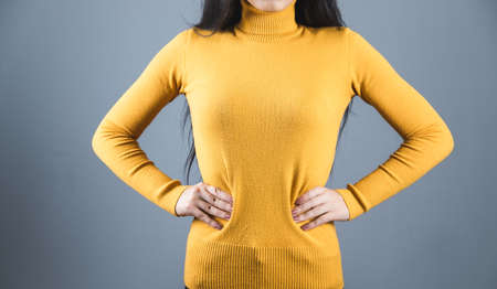 woman hand in hips on gray backgroundの写真素材