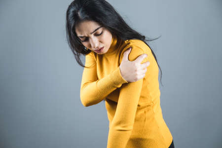 woman hand in ache hand on gray backgroundの写真素材