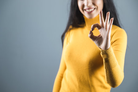 woman hand okay sign on gray backgroundの写真素材