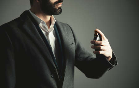 business man hand holding bottle of perfumeの写真素材