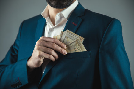 man hand money on suit pocket on gray background