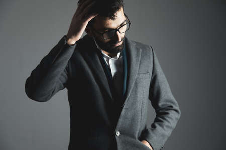 fashion man hand in hair on gray backgroundの写真素材