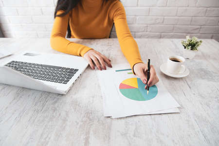 woman hand graph with computer on tableの写真素材