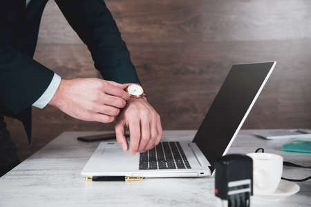 man hand clock on computer keyboard backgroundの写真素材