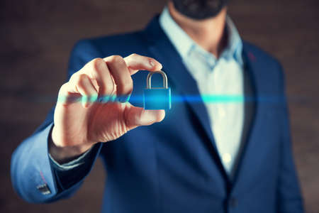 man hand holding blue lock on brown backgroundの写真素材