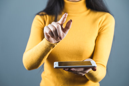 woman hand holding smart phone on gray backgroundの写真素材