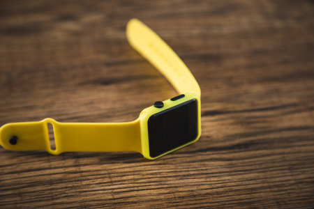 yellow smart watch on the wooden tableの写真素材