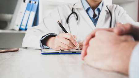 doctor hand pen with ill in room background