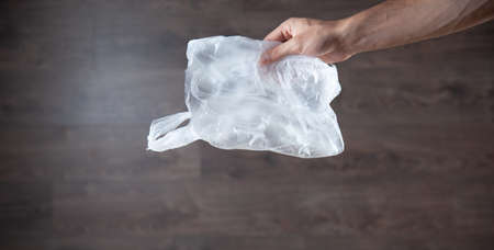 man hand polyethylene bag omthe brown backgroundの写真素材