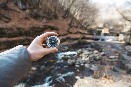 man hand compass in river with forestの写真素材