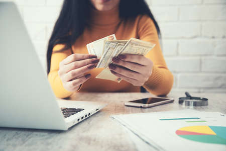woman hand holding money with computerの写真素材