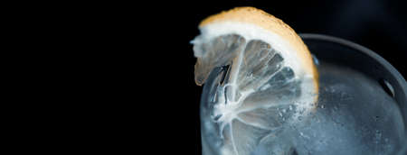 lemon on vodka of glass and bottle on tableの写真素材