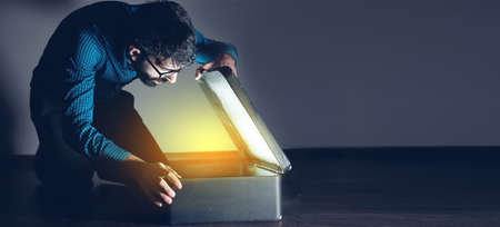 man open light gift box on dark backgroundの写真素材