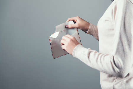 woman hand holding letter on gray backgroundの写真素材