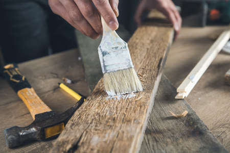 worker man hand paint brush with wood