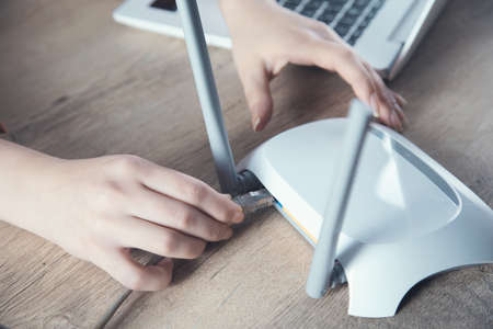 woman hand wifi device and cord on table