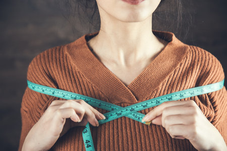 woman hand holding meter on dark backgroundの写真素材