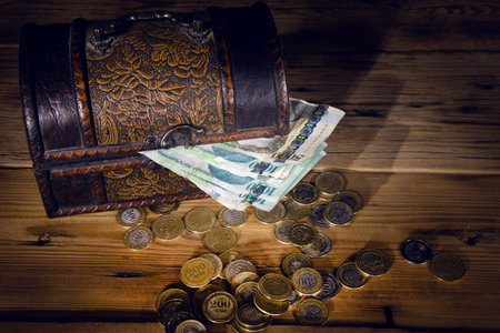 money and coins on box on the wooden table