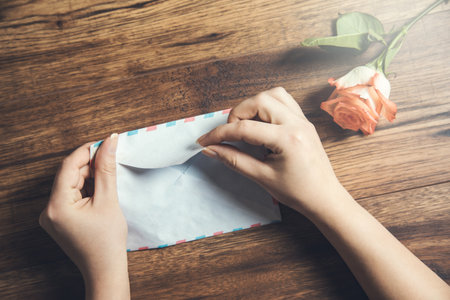 woman hand letter and roses on tableの写真素材