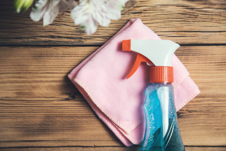 cleaning liquid and cloth with flowers on tableの写真素材