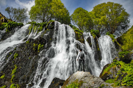 man and Shaki Waterfall in the Armeniaの写真素材