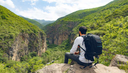 happy young traveler man in rocks background