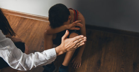 woman beating son on dark room backgroundの写真素材
