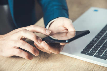 man hand phone in office desk background