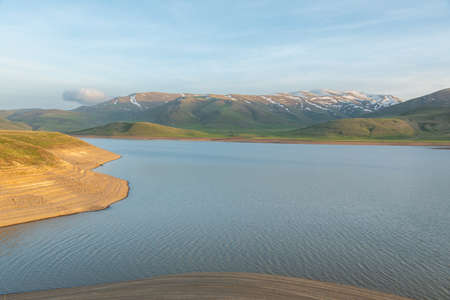 lake and green mountains under sky backgroundの写真素材