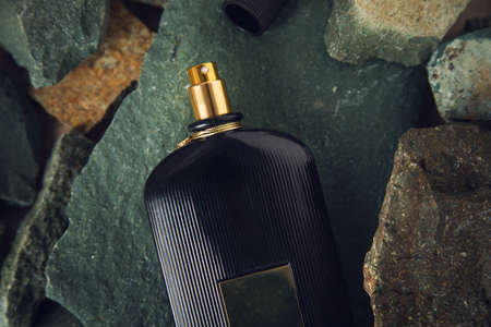 black perfume on the color stones background