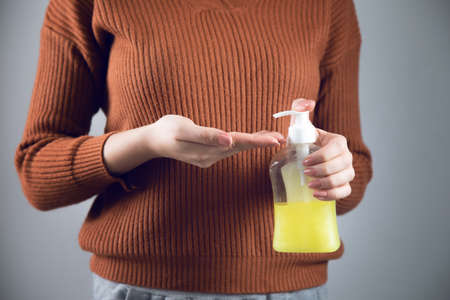 woman hand liquid soap on gray backgroundの写真素材
