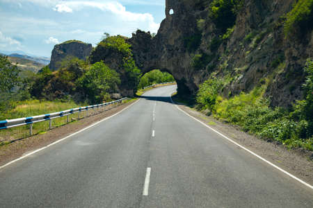 asphalt road and rocks under sky background