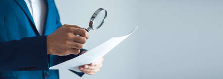 man hand magnifier and document on the gray backgroundの写真素材