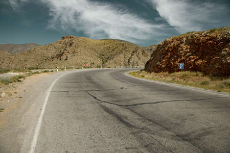 asphalt road and rocks under sky background
