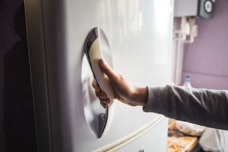 woman open the refrigerator door in kitchenの写真素材