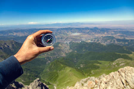 man hand compass in the mountain backgroundの写真素材