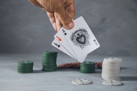 The man is playing poker on gray background