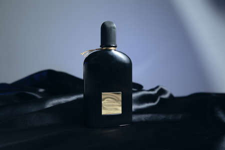 perfume on the black fabric on gray background