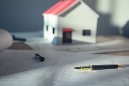 unfinished house and documents on the table backgroundの写真素材