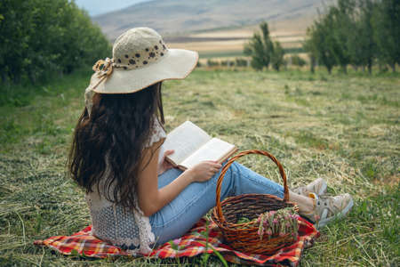 woman hand book in the field backgroundの写真素材