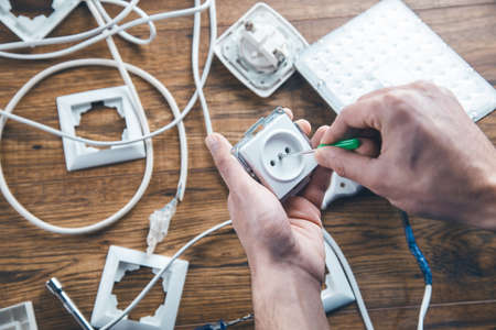 worker and tools and electrical wires on table